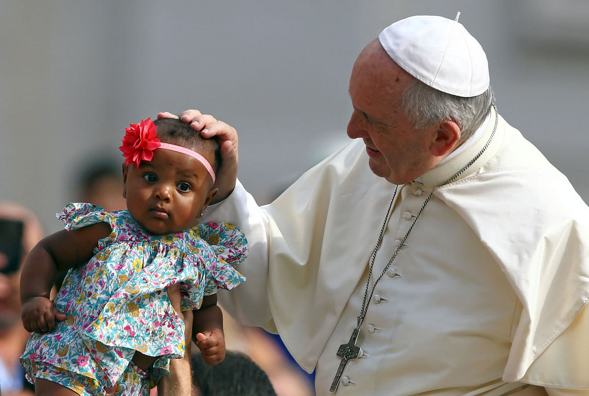 Pope Francis blesses a child as he arrives to lead the Wednesday general audience in Saint Peter`s square at the Vatican on 13 June 2018. Photo: Reuters