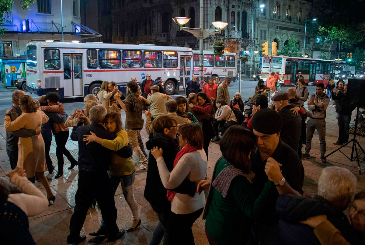 People dance tango at Entrevero square on Montevideo`s main avenue on 25 May 2018. The Montevideo city government is getting ready to launch a strategic plan, based on an assessment of the state of tango in Uruguay, to strengthen and revive this art form that emerged simultaneously in Buenos Aires and Montevideo in the late 19th century. Photo: AFP