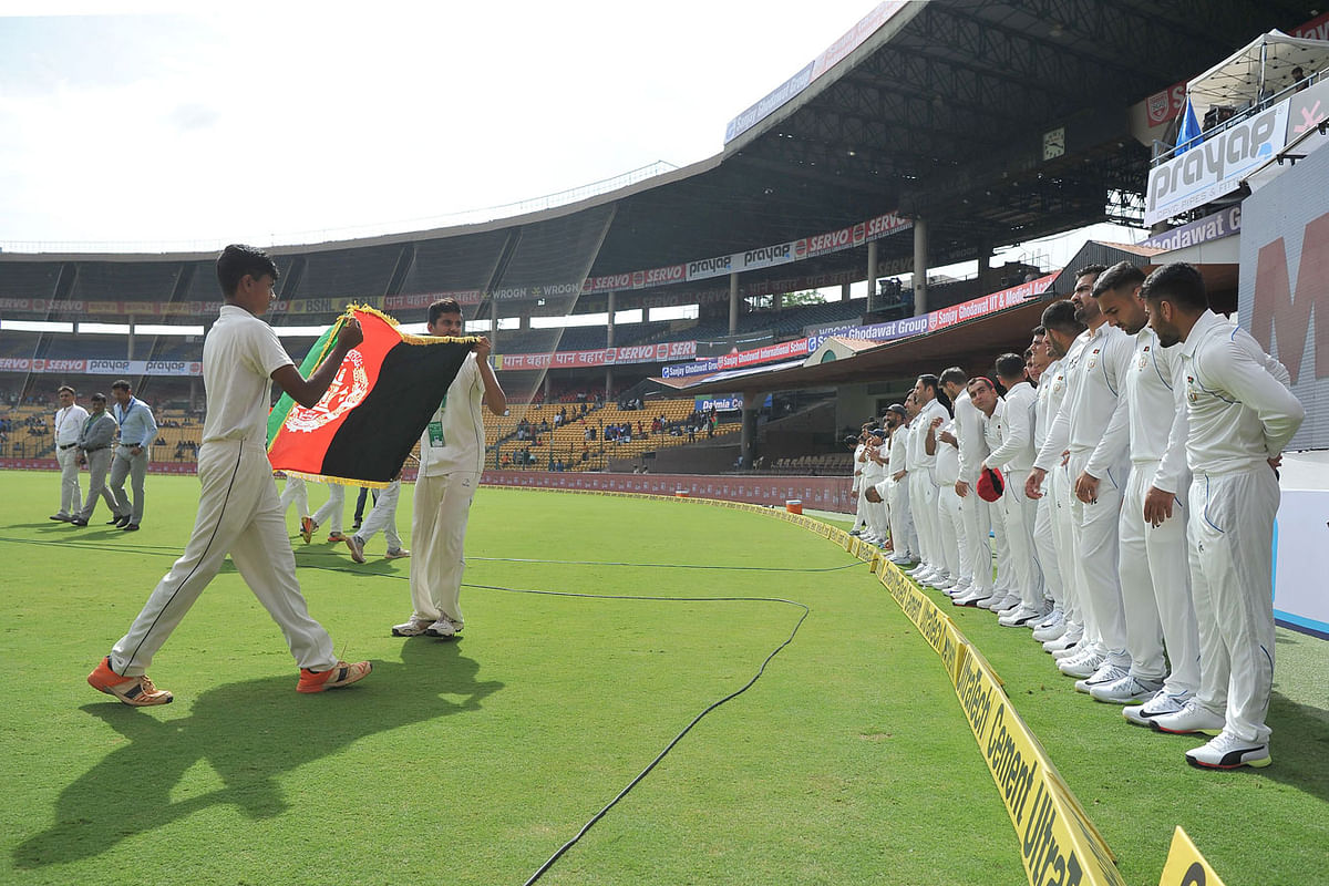 Afghan cricketers prepare to walk onto the ground before the start of the one-off cricket Test match between India and Afghanistan at The M Chinnaswamy Stadium in Bangalore on 14 June 2018. Photo: AFP