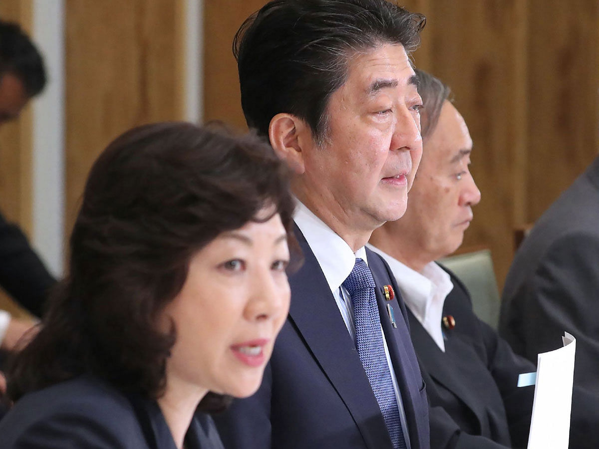 Japan`s prime minister Shinzo Abe (C), chief cabinet secretary Yoshihide Suga (R) and internal affairs minister Seiko Noda (L), who also serves as women`s empowerment minister, attend a meeting with cabinet members at Abe`s official residence in Tokyo on 12 June 2018. Photo: AFP