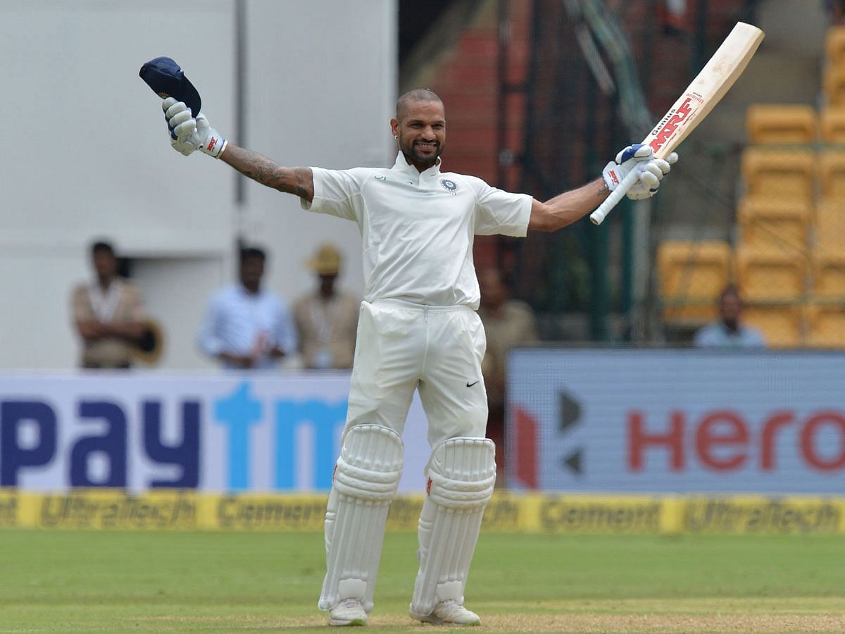 India`s batsman Shikhar Dhawan celebrates his century (100 runs) during the first day of the one-off cricket Test match against Afghanistan at The M Chinnaswamy Stadium in Bangalore on 14 June 2018. Photo: AFP
