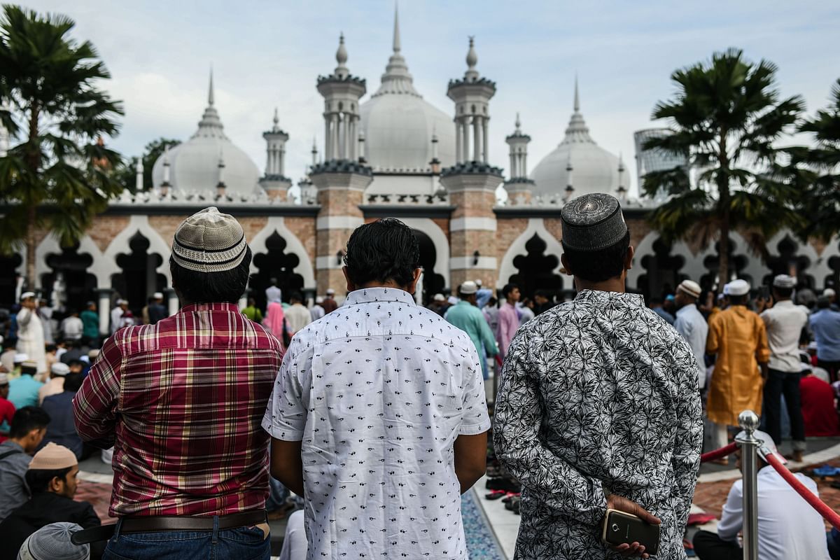 Muslims wait for Eid al-Fitr prayers at the Jamek Mosque in Kuala Lumpur. Photo: AFP