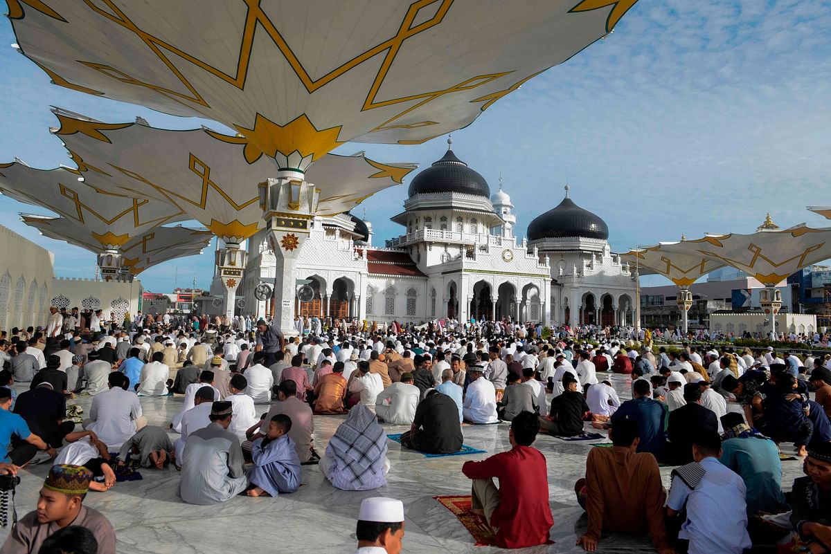 Indonesian Muslims take part in a morning prayer celebrating the Eid al-Fitr festival at the Baiturrahman mosque in Banda Aceh. Millions in Indonesia, the world`s most populous Muslim country, are celebrating Eid with family reunions and feasts of traditional food after a month of prayer and fasting. Photo:  AFP