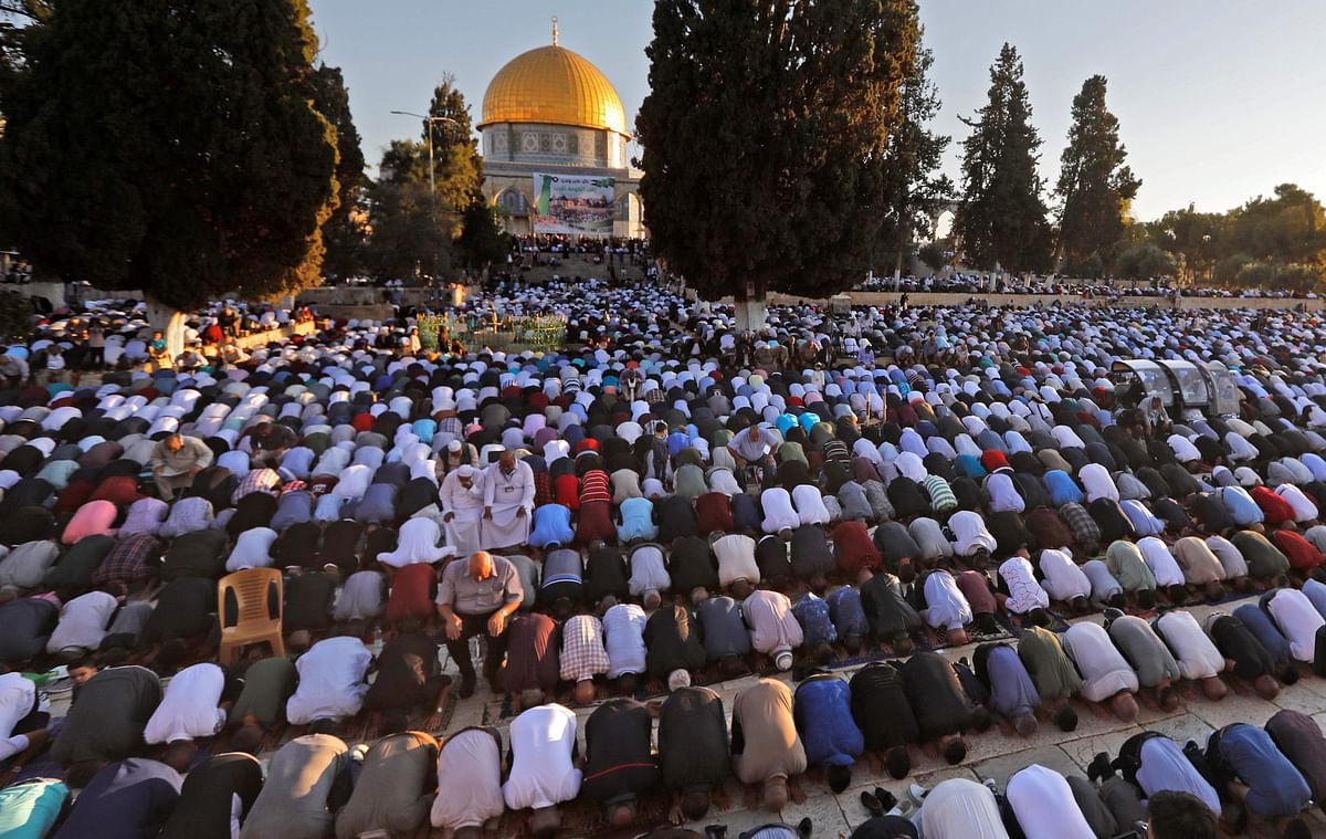 Palestinian Muslims perform the morning Eid al-Fitr prayer near the Dome of Rock at the Al-Aqsa Mosque compound, Islam`s third most holy site, in the Old City of Jerusalem Photo: AFP
