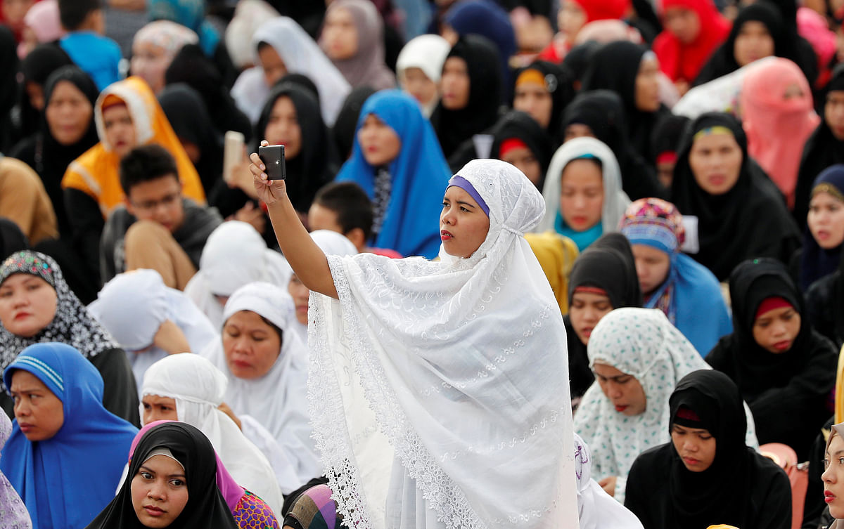 A Filipino Muslim woman takes a selfie during the first day celebration of Eid al Fitr at Luneta Park in Manila, Philippines. Photo: Reuters