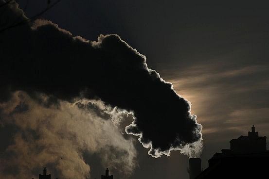 Smoke from a chimney is silhouetted against the rising sun in Harbin. Photo: Reuters