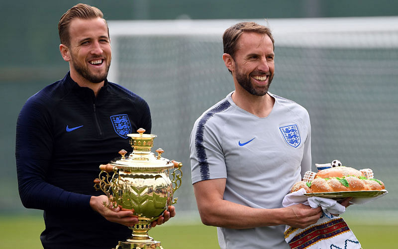 England coach Gareth Southgate (R) carries a cake next to captain Harry Kane (L) during a training session in Zelenogorsk, on June 13, 2018. AFP