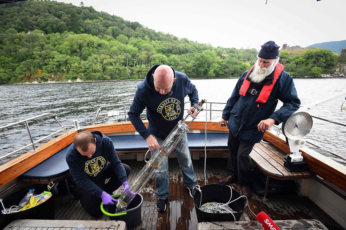 Professor Neil Gemmell (C) takes samples on his boat as he conducts research into the DNA present in the waters of Loch Ness in the Scottish Highlands, Scotland on 11 June 2018. Tales of a giant creature lurking beneath the murky waves of Loch Ness have been around for more than 1,500 years -- and one academic hopes the marvels of modern science can finally unravel the mystery. Photo: AFP