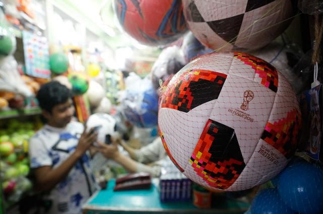 Young adults are especially enthusiastic during the FIFA World Cup. In this recently taken photo by Dipu Malakar, a young boy is buying a football from a shop in Old Dhaka