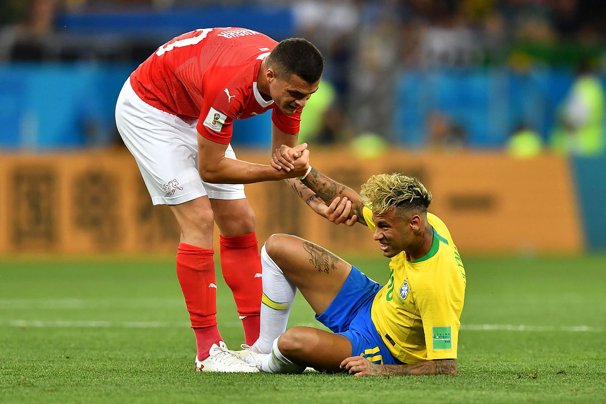 Switzerland`s midfielder Granit Xhaka (L) helps Brazil`s forward Neymar during the Russia 2018 World Cup Group E football match between Brazil and Switzerland at the Rostov Arena in Rostov-On-Don on 17 June 2018. Photo: AFP
