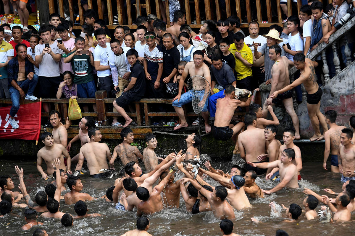 Men catch ducks in Tuojiang river during the Dragon Boat festival in Fenghuang, Hunan province, China 18 June. Photo: Reuters