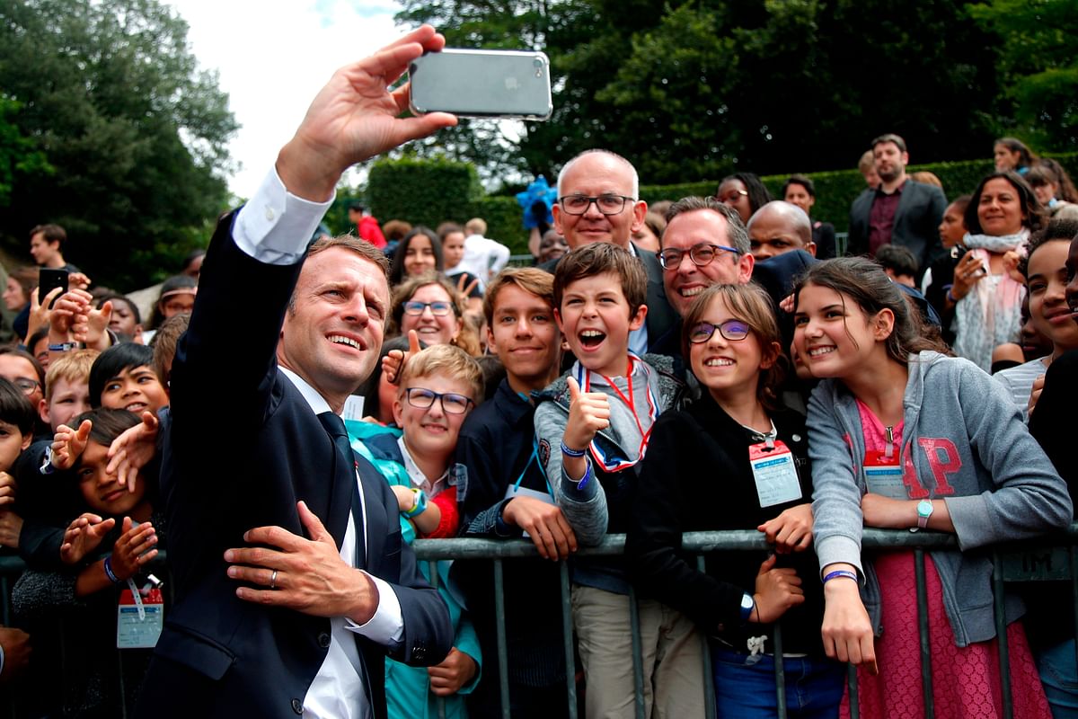 French president Emmanuel Macron (C) takes a `selfie` with members of the crowd, as he leaves after a ceremony commemorating General Charles De Gaulle`s June 1940 appeal for French resistance against Nazi Germany, at the Mont Valerien National Memorial in Suresnes on the outskirts of Paris on 18 June 2018. Photo: AFP