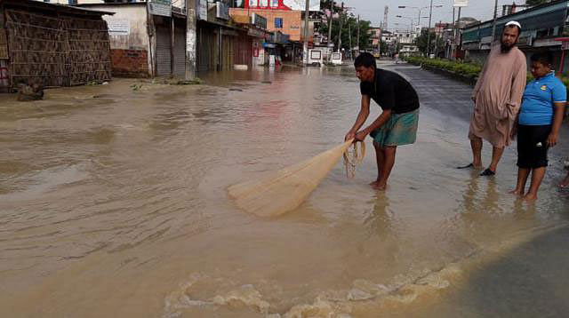 A man tries to throw a net for fishing on flooded Dhaka-Sylhet highway. Photo: Prothom Alo
