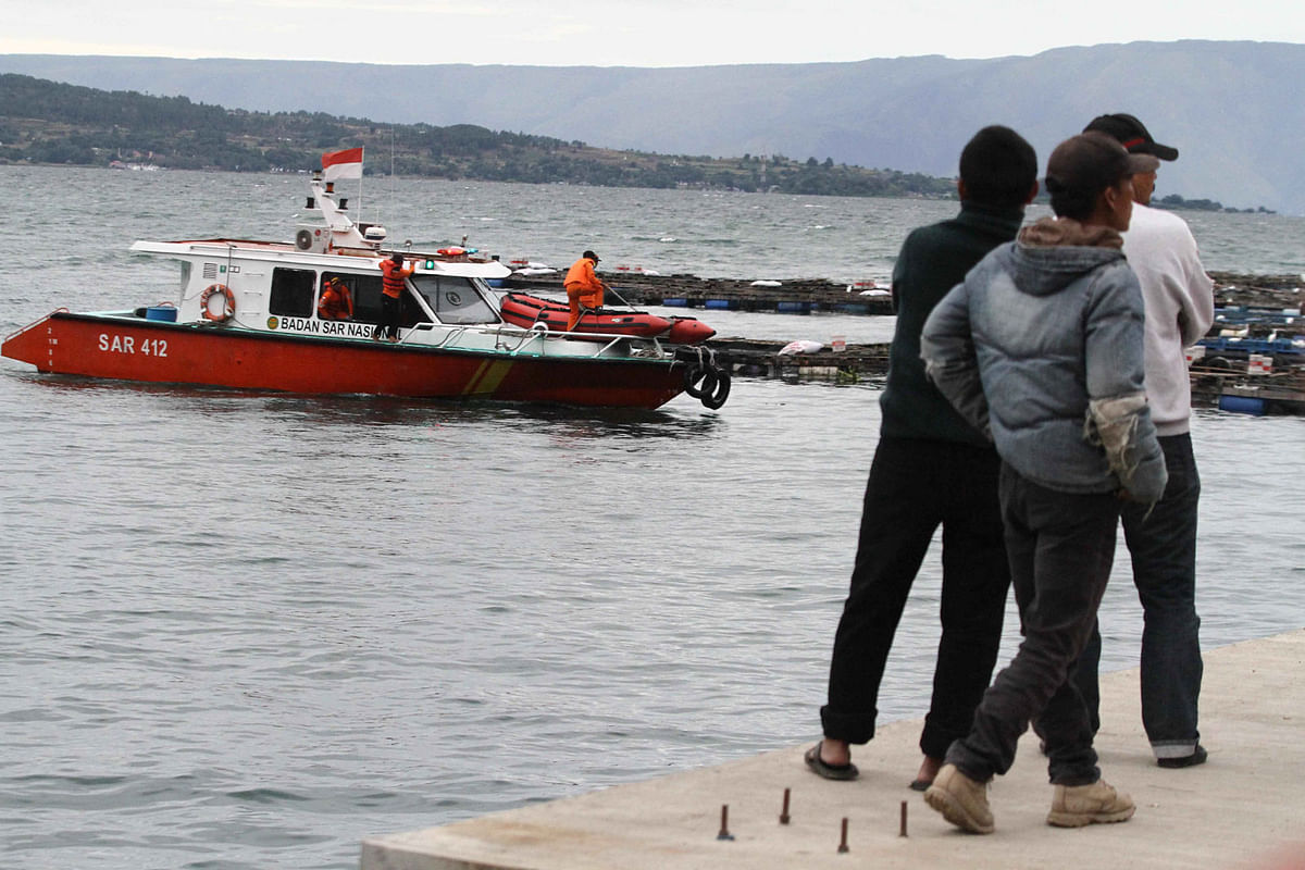 People watch a search and rescue boat used in the search for missing passengers on a ferry that sank in Lake Toba. Photo: Reuters