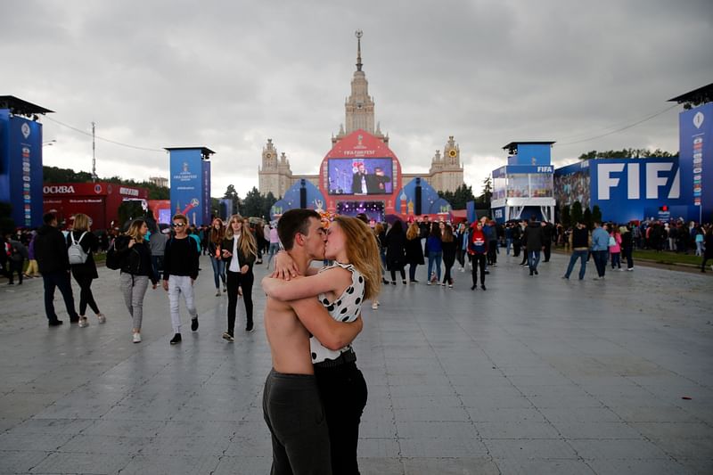 In this file photograph taken on June 10, 2018, a couple kiss during the official opening ceremony of the FIFA Fan Fest in Moscow, near the main building of the Lomonosov Moscow State University (MSU), ahead of the start of the Russia 2018 World Cup. Moscow`s World Cup fan zone, built on the doorstep of the city`s iconic main university, has become a `flirt zone,` joked the free Russian paper Metro. For older Russians, such romances are reminiscent of other major international events in Moscow, such as the 1980 Olympic Games hosted by the USSR during the Cold War. AFP