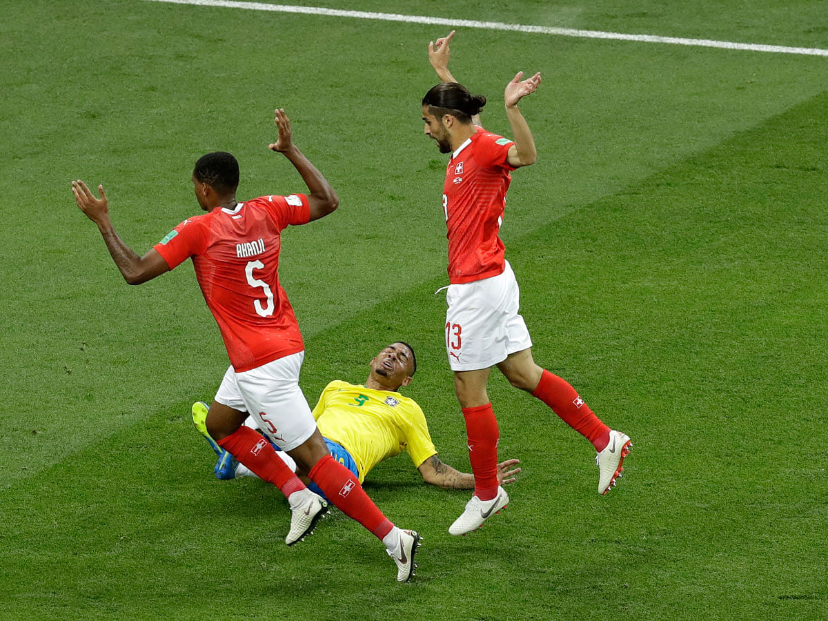 Brazil`s Gabriel Jesus falls down as Switzerland`s Manuel Akanji, left, and Ricardo Rodriguez hold up their hands during the group E match between Brazil and Switzerland at the 2018 soccer World Cup in the Rostov Arena in Rostov-on-Don, Russia, Sunday 17 June 2018. Photo: AP
