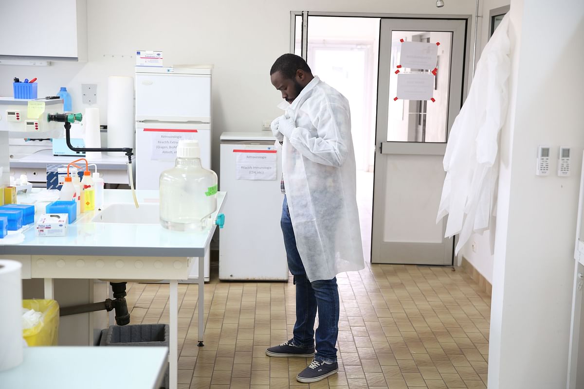 Dr Mombo dons his white coat as he prepares to analyse samples at the Franceville International Centre of Medical Research (CIRMF) is seen on 12 June 2018 in Franceville. Researchers call it P4: this highly secure laboratory, one of only two in Africa to treat the most dangerous viruses, including Ebola, is located well away from the main buildings of the International Medical Research Center of Franceville (CIRMF) in Gabon. Photo: AFP