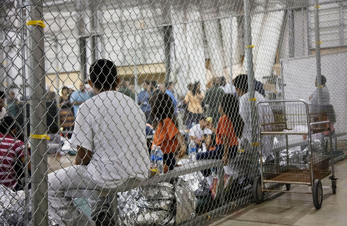 In this photo provided by US Customs and Border Protection, people who`ve been taken into custody related to cases of illegal entry into the United States, sit in one of the cages at a facility in McAllen, Texas, Sunday, 17 June, 2018