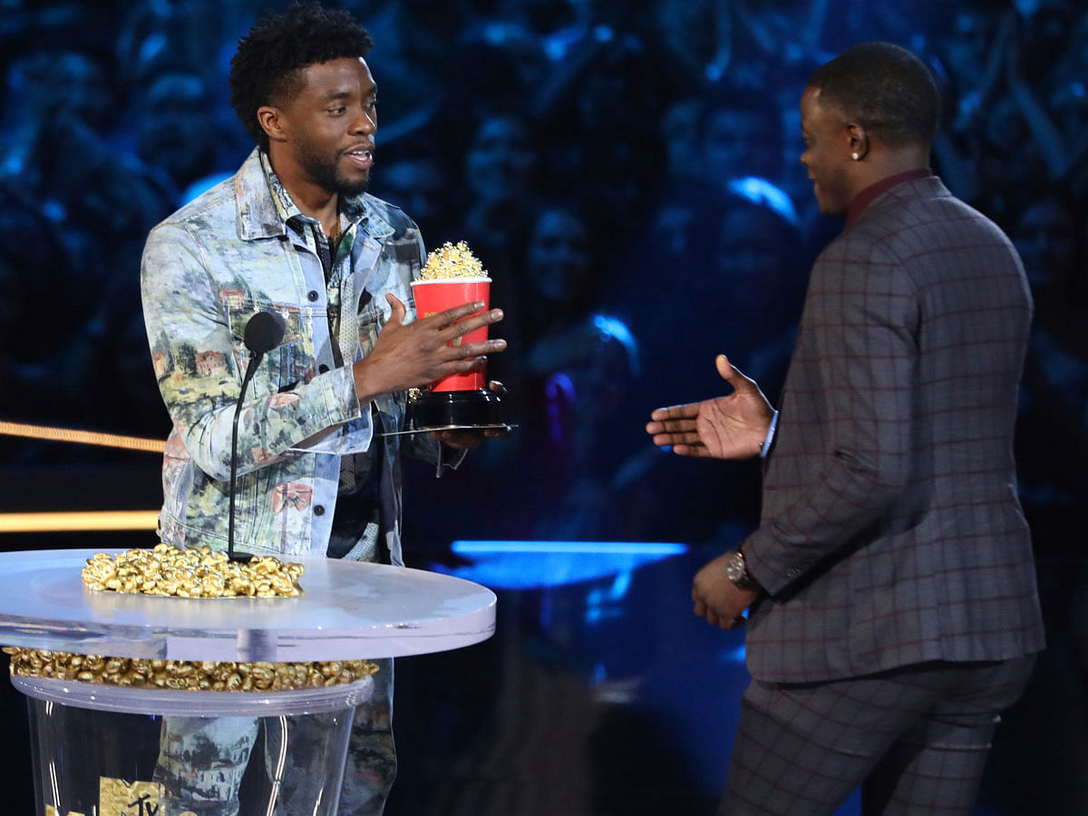 In this 16 June photo, Chadwick Boseman, left, gives his best hero award for his role in “Black Panther” to James Shaw Jr, who is credited with saving lives during a shooting at a Waffle House in Antioch, Tenn, at the MTV Movie and TV Awards at the Barker Hangar in Santa Monica, California. Photo: AP