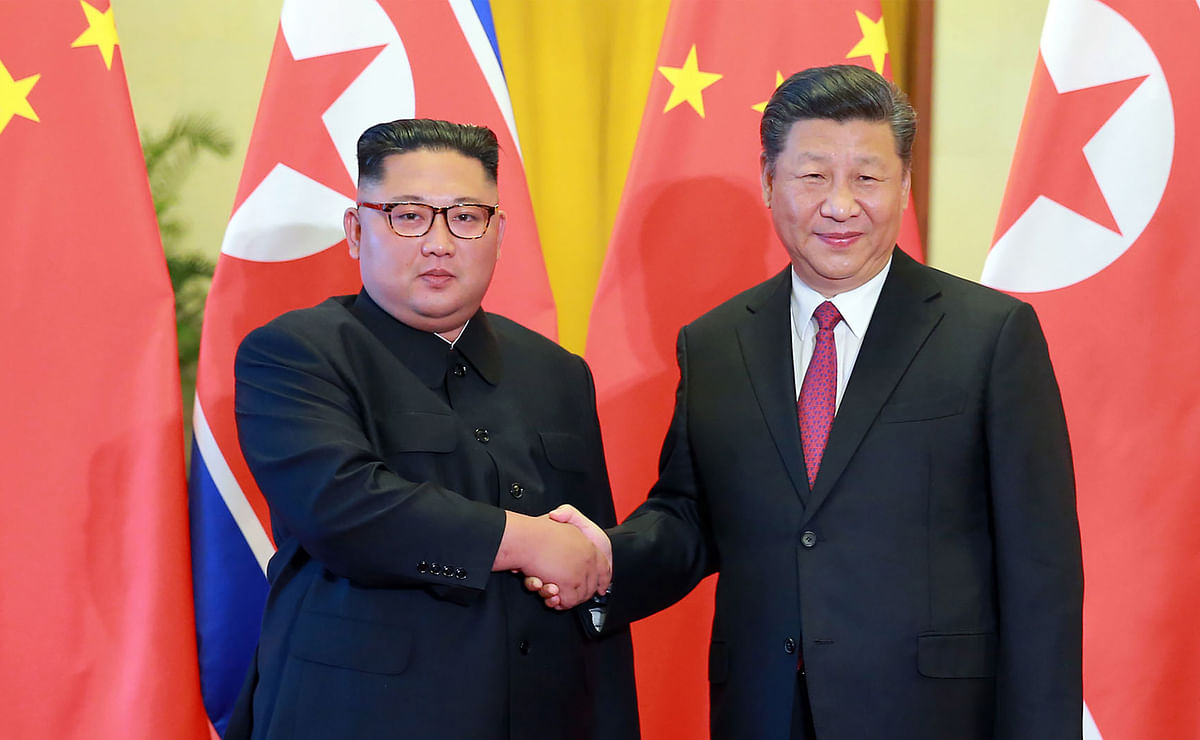 This picture taken on 19 June 2018 and released by North Korea`s official Korean Central News Agency (KCNA) via KNS on 20 June 2018 shows North Korean leader Kim Jong Un (L) shaking hands with Chinese president Xi Jinping at the Great Hall of the People in Beijing.  Meta: Kim Jong Un declared North Korea’s unstinting “friendship, unity and cooperation” with Beijing during his third visit to China this year, in a show of loyalty to his main ally following a landmark summit with US president Donald Trump.