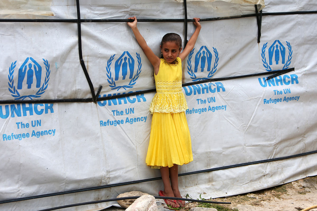 A Syrian refugee girl stands outside a tent as she poses at a refugee camp in Zahrani town, southern Lebanon on 13 June 2018. Photo: Reuters