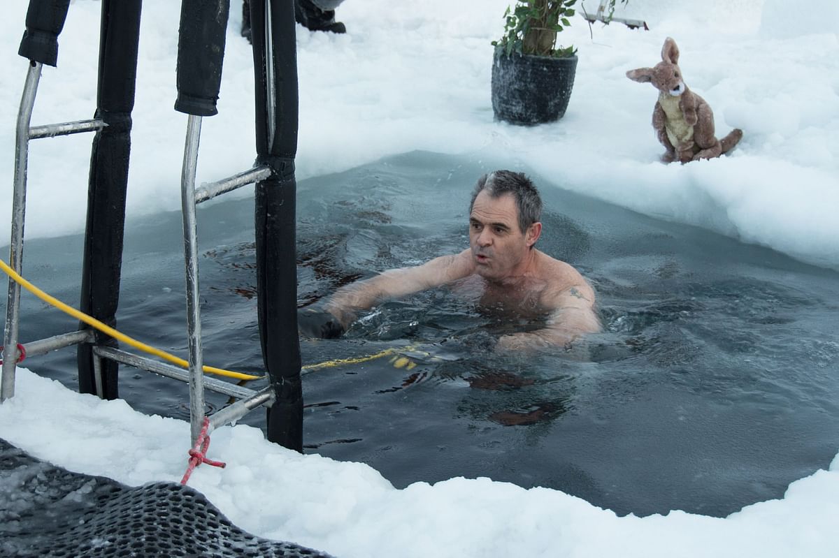 This handout photo taken on 19 June 2018 and released by the Australian Antarctic Division (AAD) on 21 June shows Barry Balkin taking a dip in a swimming hole prepared at the Casey research station as Antarctic researchers welcome the winter solstice by plunging into icy waters as part of a `mad tradition` as they look forward to brighter days after weeks of darkness. Photo: AFP