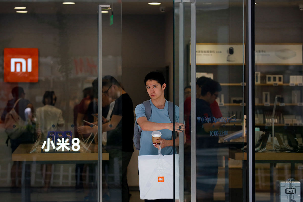 In this Wednesday, 20 June 2018, photo, a man with purchased goods walks out from the Xiaomi store in Beijing. Xiaomi, a Chinese start-up that helped to pioneer the trend toward ultra-low-priced smartphones, is preparing for what would be the biggest initial public offering since e-commerce giant Alibaba`s in 2014. Photo: AP