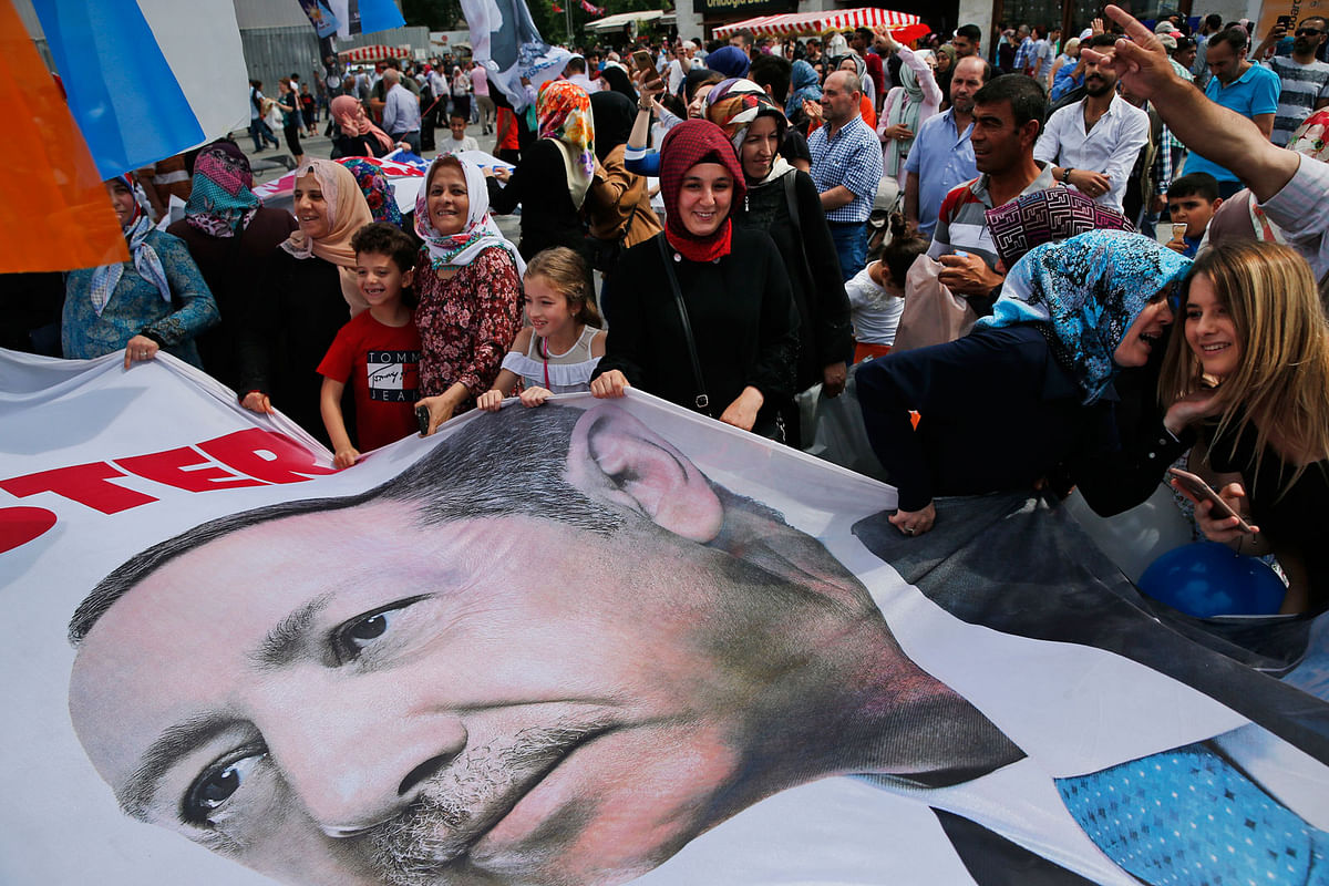 In this photo taken on Wednesday, 20 June, 2018, people wave a banner with a picture of Turkey`s president Recep Tayyip Erdogan, during a gathering of supporters of his ruling Justice and Development Party (AKP) in Istanbul. The most powerful and polarising leader in Turkish history is standing for re-election in a presidential vote on Sunday that could cement Turkey`s switch from a parliamentary to a presidential system, which was narrowly approved in a referendum last year. Photo : AP