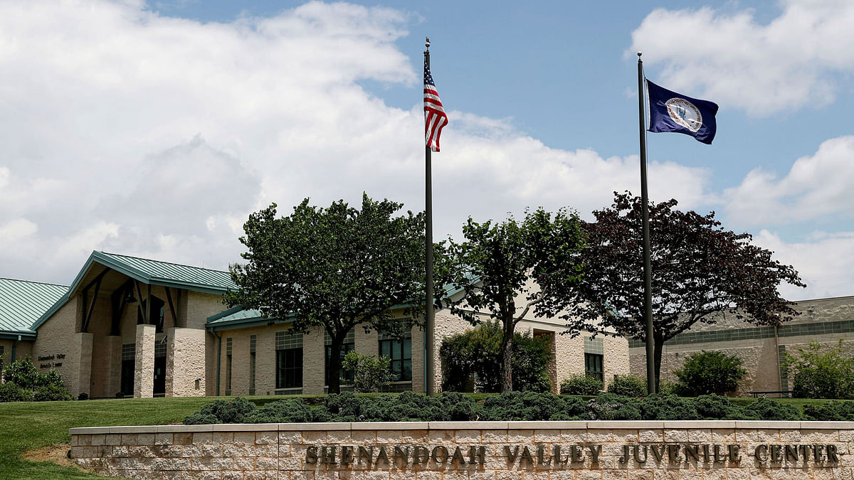 A person walks into the entrance of the Shenandoah Valley Juvenile Center on Wednesday, 20 June, 2018 in Staunton, Va. Immigrant children as young as 14 housed at the juvenile detention center say they were beaten while handcuffed and locked up for long periods in solitary confinement, left nude and shivering in concrete cells. The abuse claims are detailed in federal court filings that include a half-dozen sworn statements from Latino teens jailed there for months or years. Photo : AP
