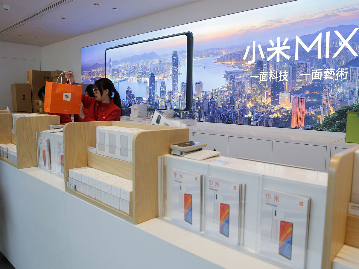 In this Wednesday, 20 June 2018 photo, a shop assistant works at a counter in a Xiaomi store in Hong Kong. Xiaomi, a Chinese start-up that helped to pioneer the trend toward ultra-low-priced smartphones, is preparing for what would be the biggest initial public offering since e-commerce giant Alibaba`s in 2014. Photo: AP