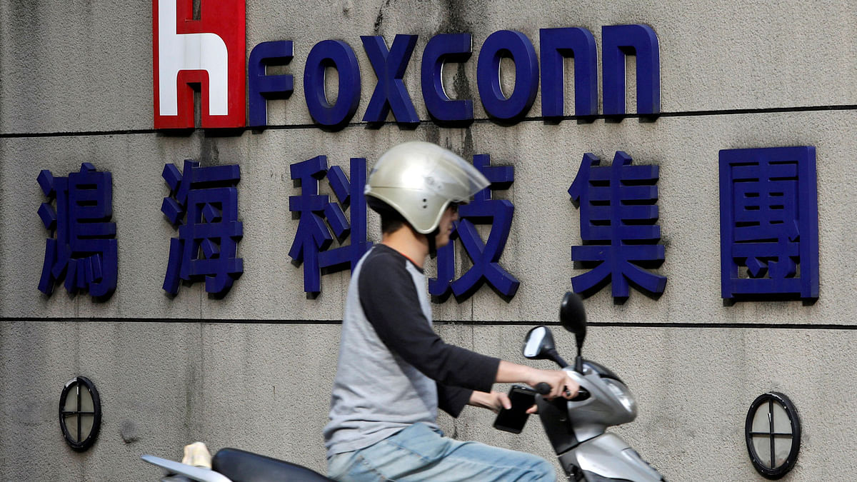 A motorcyclist rides past the logo of Foxconn, the trading name of Hon Hai Precision Industry, in Taipei, Taiwan on 30 March. Photo: Reuters