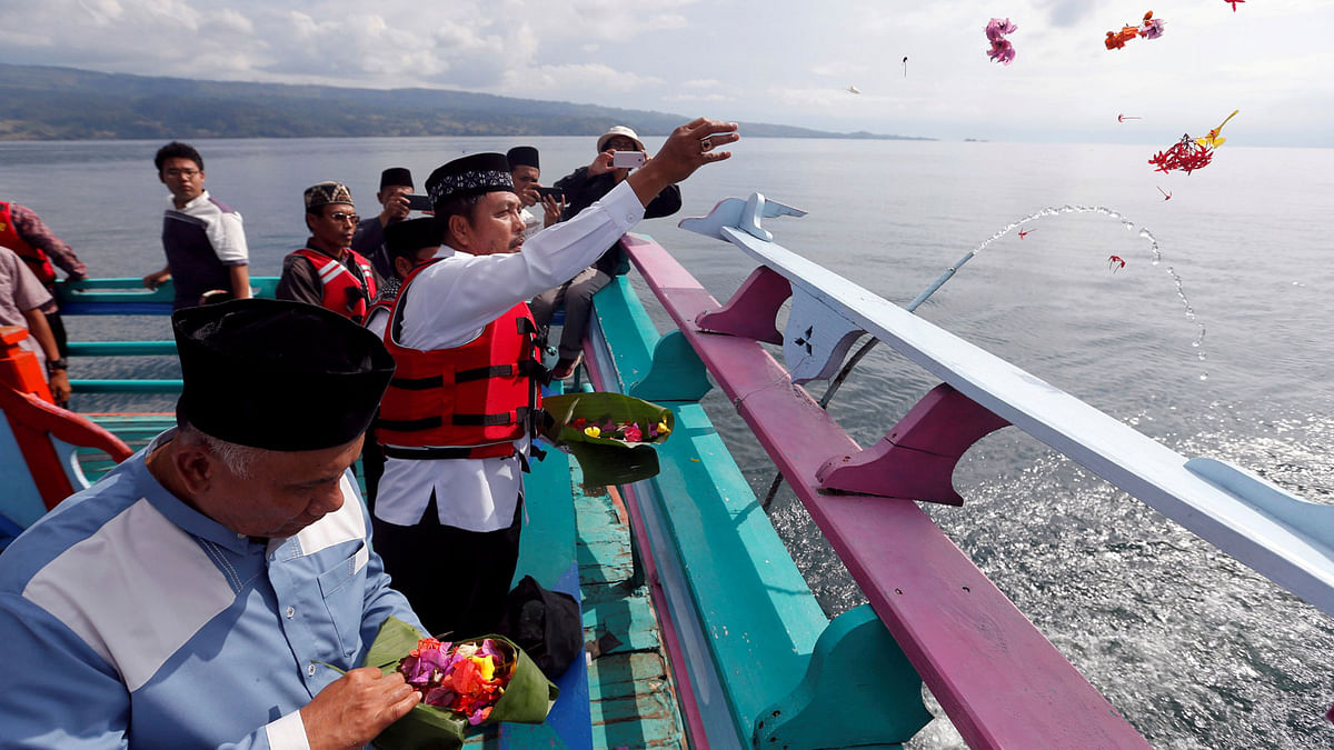 Villagers and Muslim clerics throws flowers after praying for the missing passengers, after a ferry sank earlier this week in Lake Toba in Simalungun, North Sumatra, Indonesia on 22 June. Photo: Reuters
