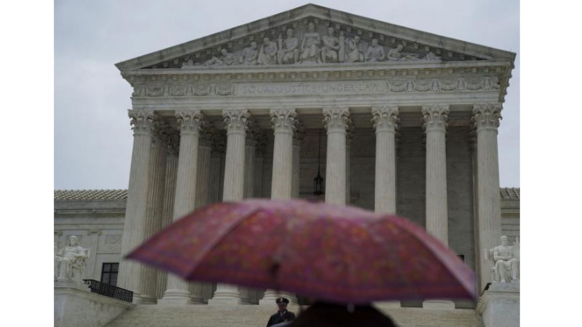 A person walks with an umbrella prior to the US Supreme Court`s decision to impose limits on the ability of police to obtain cellphone data pinpointing the past location of criminal suspects, outside the US Supreme Court in Washington, on 22 June 2018. -- Reuters