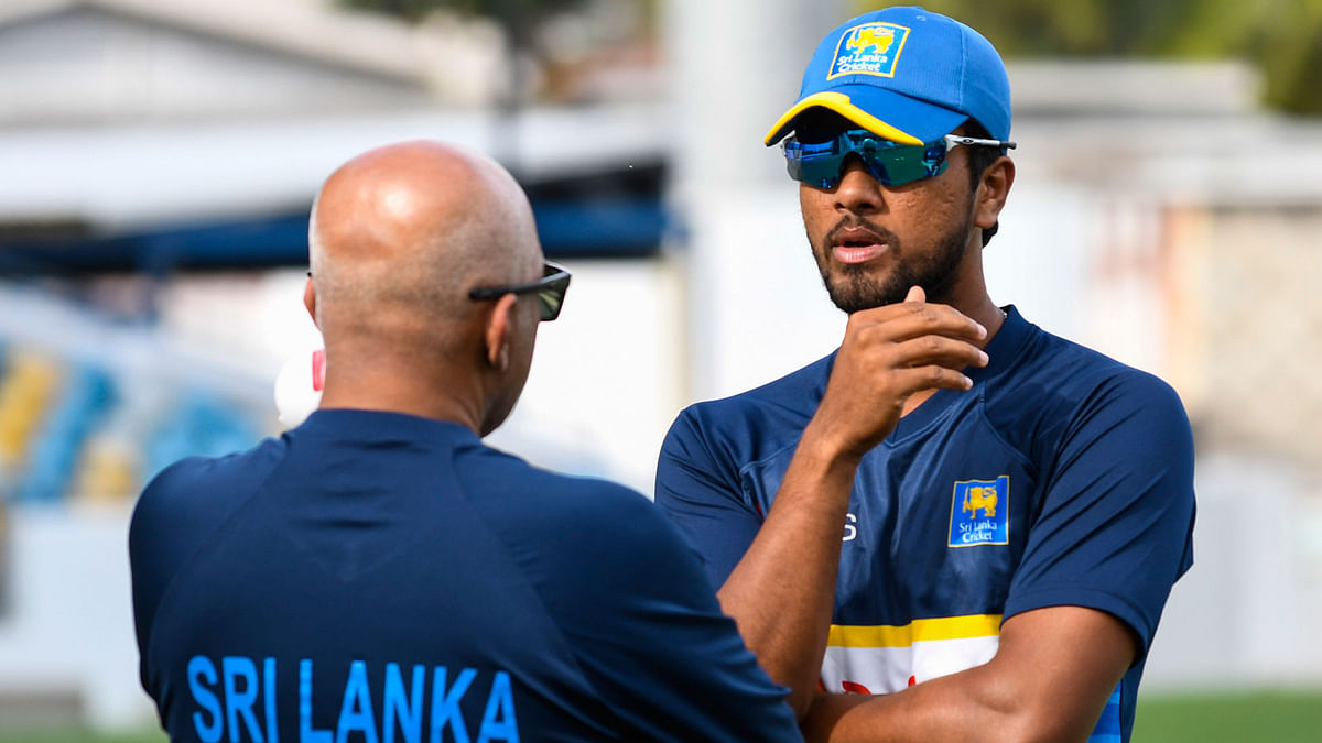 Dinesh Chandimal (R) chat with Chandika Hathurusingha (L) of Sri Lanka take part in a training session one day before the 3rd Test against West Indies at Kensington Oval, Bridgetown, Barbados, on 22 June 2018. Photo: AFP