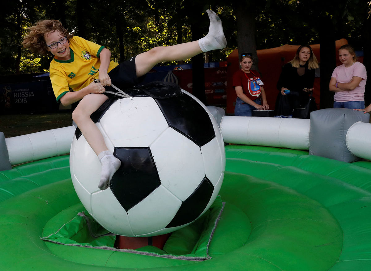 A teenager rides a mechanical soccer ball at the 2018 FIFA World Cup Fan Fest in Moscow, Russia on 22 June. Photo: Reuters