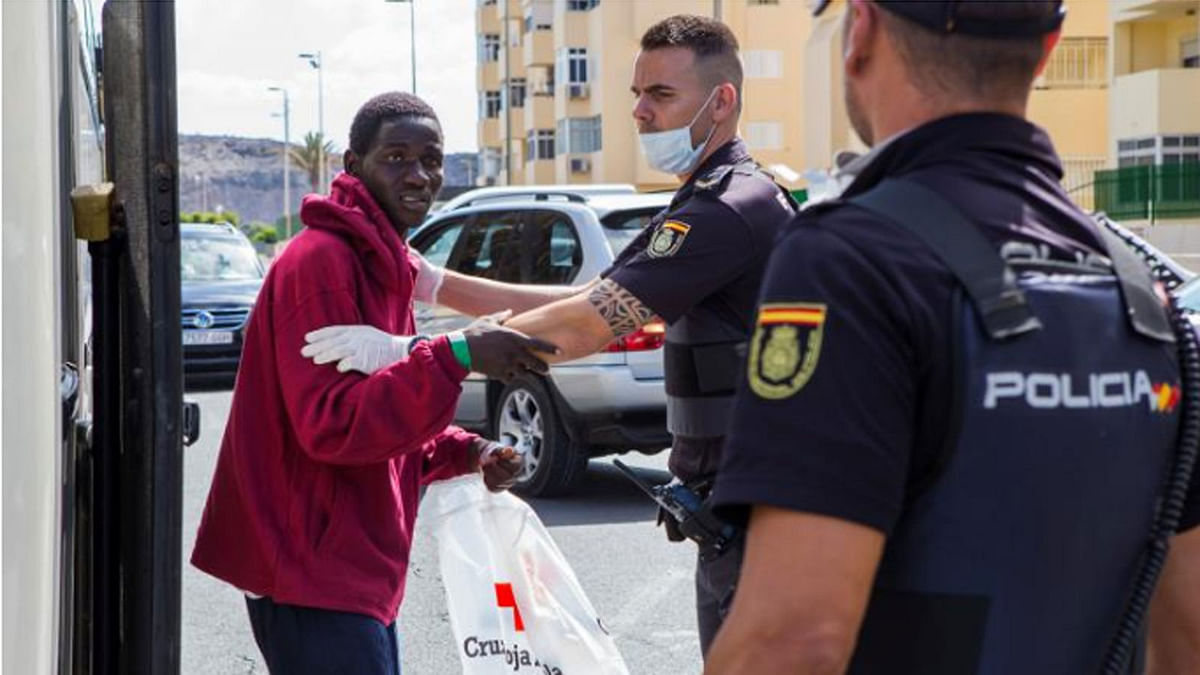 A migrant, part of a group intercepted aboard a make-shift boat at sea south of Spain`s Canary Islands, is escorted by Spanish police after arriving in Maspalomas, on the island of Gran Canaria, Spain, on 23 June 2018. -- Reuters