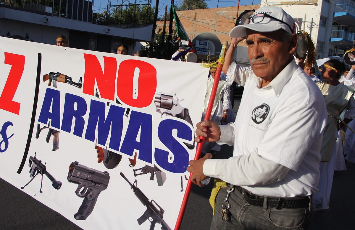 A man holds a sign reading `No weapons` during the march for peace and against violence in Ciudad Juarez, Chihuahua state, Mexico, on 23 June. Photo: AFP