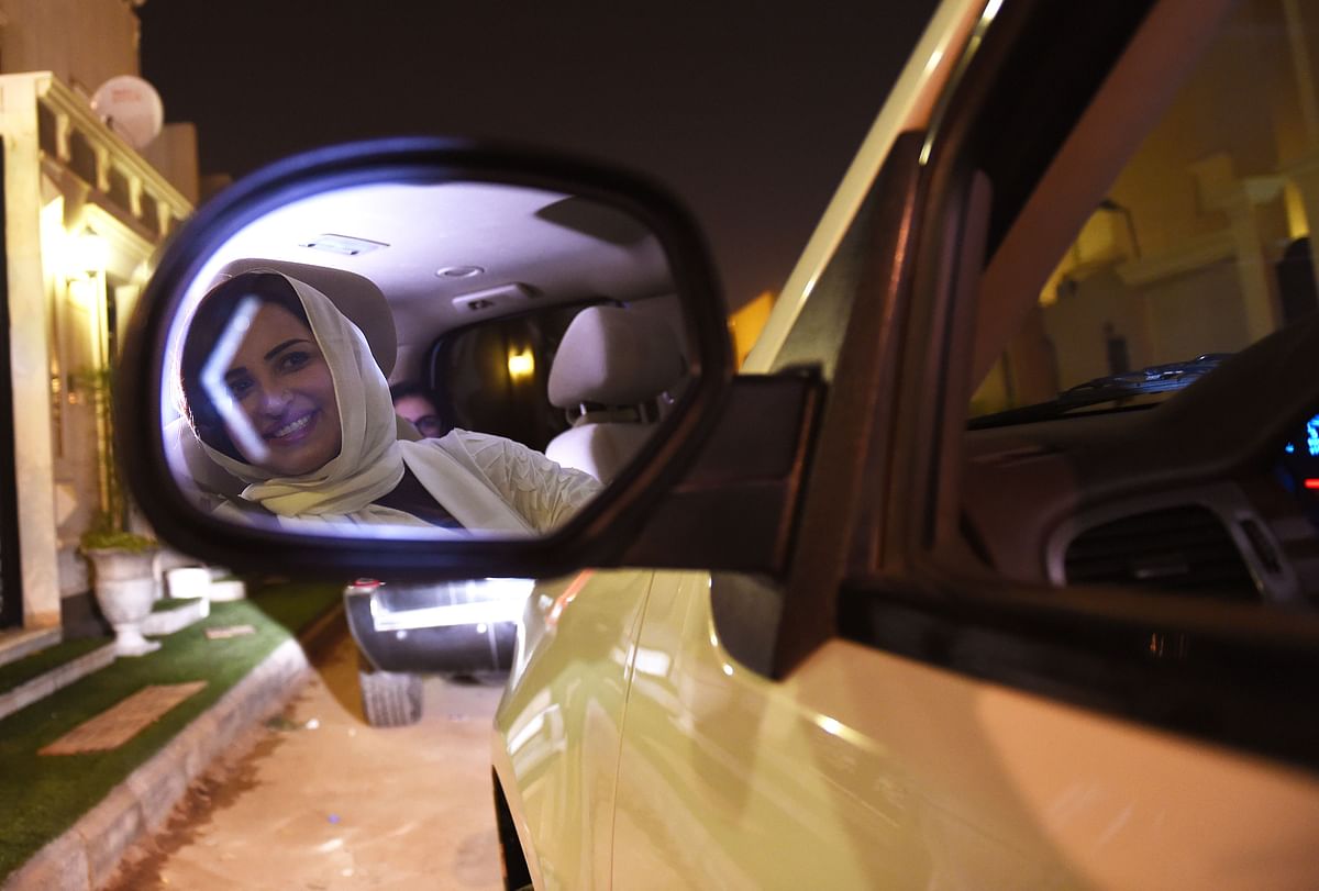 Saudi Samar Al-Moqren is seen in her car`s rear-view mirror as she drives through Riyadh city`s streets for the first time just after midnight 24 June 2018, when the law allowing women to drive took effect. Photo: AFP