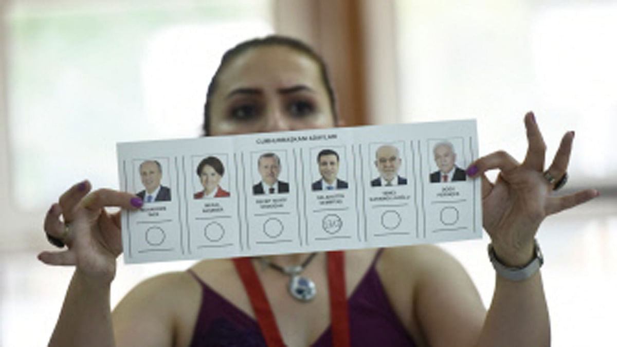 An election committee member shows a ballot displaying a vote for Selahattin Demirtas, presidential candidate of the pro-Kurdish People`s Democratic Party (HDP) at a polling station during the Turkish presidential and parliamentary elections in Istanbul on 24 June 2018. Turks voted on 24 June in dual parliamentary and presidential polls seen as the president`s toughest election test, with the opposition revitalised and his popularity at risk from growing economic troubles. Photo : AFP