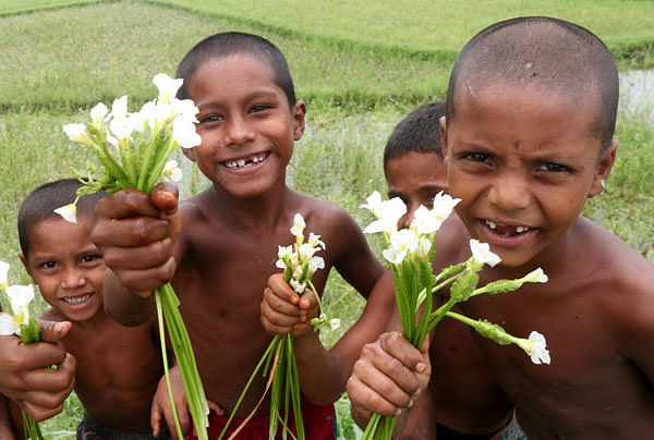 Flowers in their hands and smiles on their faces, children pose for Soel Rana’s camera Gabtali upazila of Bogura on 25 June.