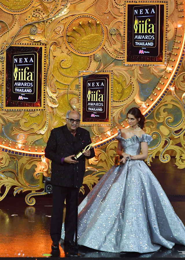Bollywood film producer Boney Kapoor (L) receives the award for best performance in a leading role - female in behalf of his late wife and actress Sridevi for her role in “Mom” while Bollywood actress Kriti Sanon ® looks on during the IIFA Awards of the 19th International Indian Film Academy (IIFA) festival at the Siam Niramit Theatre in Bangkok on 24 June. Photo: AFP