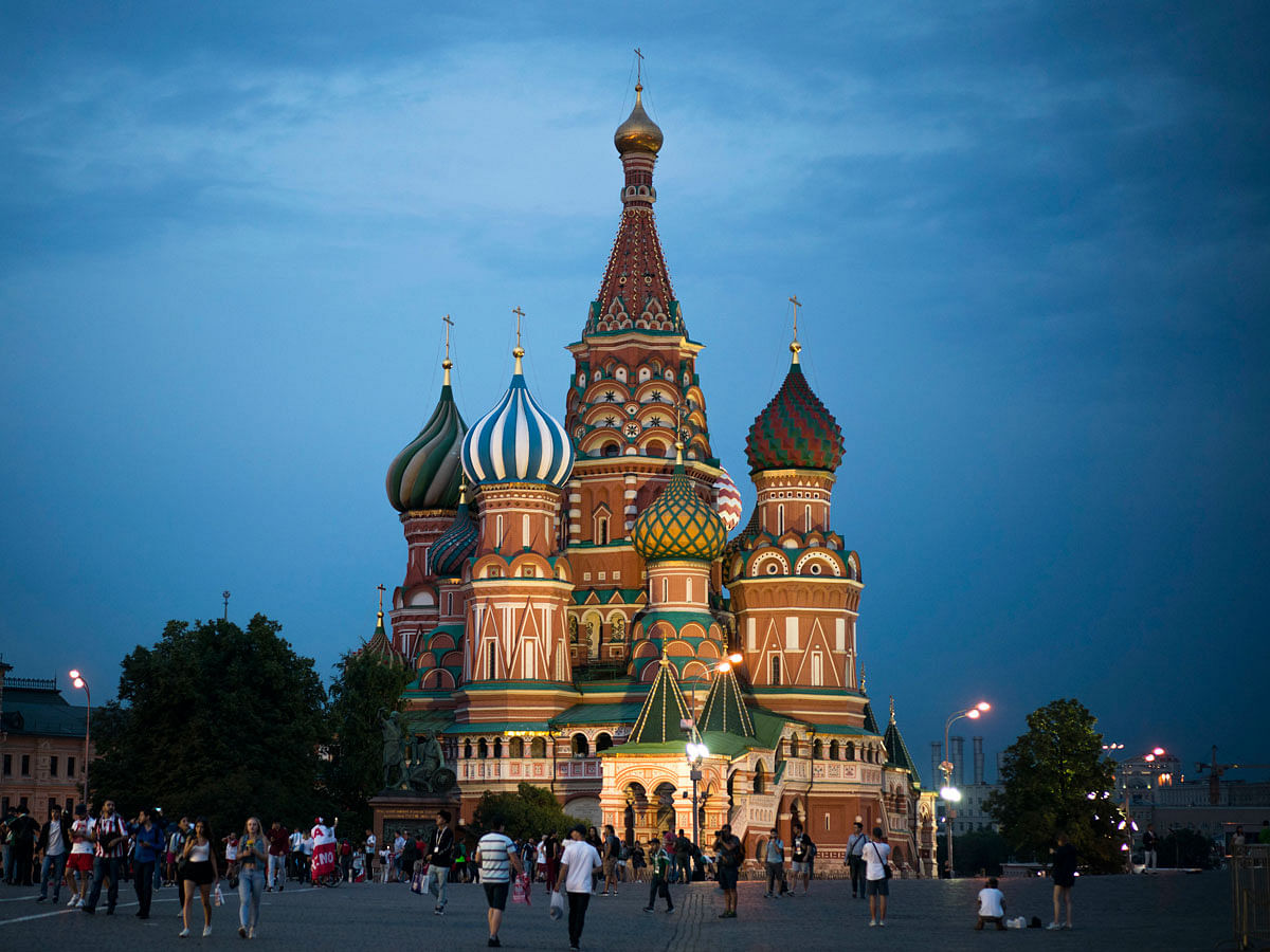 Tourists walk near the Saint Basil’s Cathedral at dusk during the 2018 soccer World Cup in Moscow, Russia on 19 June. Photo: AP