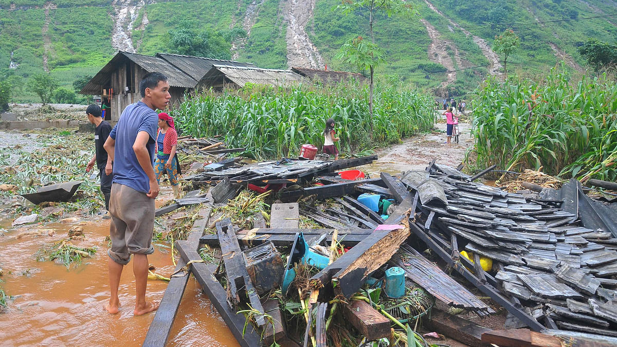 In this picture taken on 25 June 2018 shows a Vietnamese man looking at the debris of his house destroyed by flash floods in northern Ha Giang province. Flash floods and landslides killed 15 people in Vietnam`s mountainous north, officials said on June 26, 2018, after storms ravaged homes and wiped out crops and infrastructure. AFP