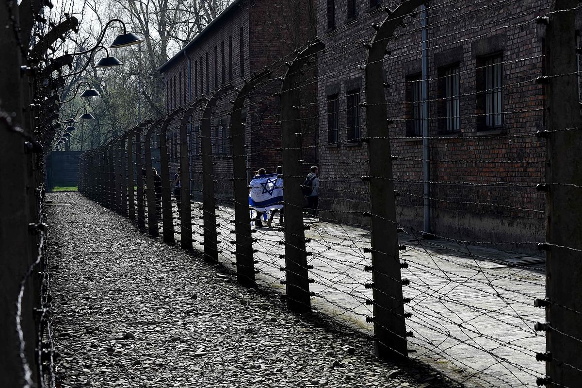 In this file photo taken on 12 April 2018 participants are wrapped into an Israeli flag as they arrive to the memorial site of the Auschwitz-Birkenau Nazi death camp in Oswiecim to attend the annual `March of the Living`. Poland`s prime minister on 27 June 2018 proposed an amendment to a controversial Holocaust law that has stoked tension with Israel by imposing jail terms on anyone ascribing co-responsibility of the Polish state for Nazi German war crimes, a senior aide said. Photo: AFP