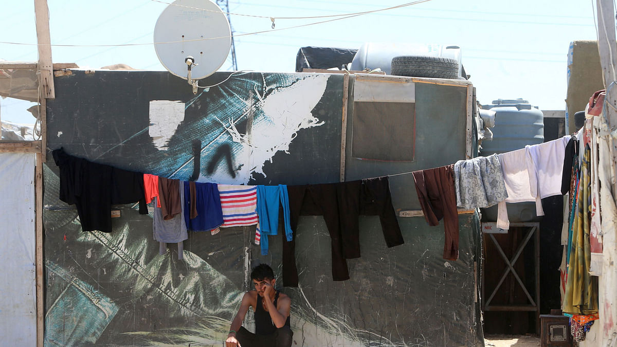A young Syrian man sits outside a tent in a refugee camp on the outskirts of the town of Zahle in Lebanon`s Bekaa Valley on 23 June 2018. Eking out a living in dilapidated camps in east Lebanon has been hell for Syrian refugees, but the alternative is worse. Going home means taking up arms. For men above 18 years of age, one particular fear is keeping them out of their homeland: conscription. Photo: AFP