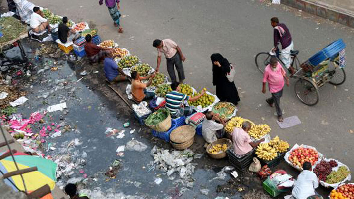 Sewerage water, illegal makeshift fruit shops leave little space for the pedestrians and vehicle at a road in Satmatha, Bogura on 26 June. Photo: Soel Rana