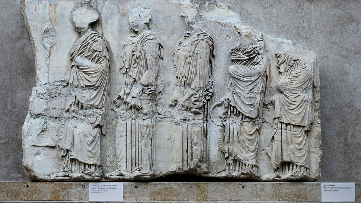 Five girls walk in a single file, part of a collection of stone objects, inscriptions and sculptures, known as the Elgin Marbles displayed at the Parthenon Marbles` hall at the British Museum in London on 16 October 2014. Photo: Reuters