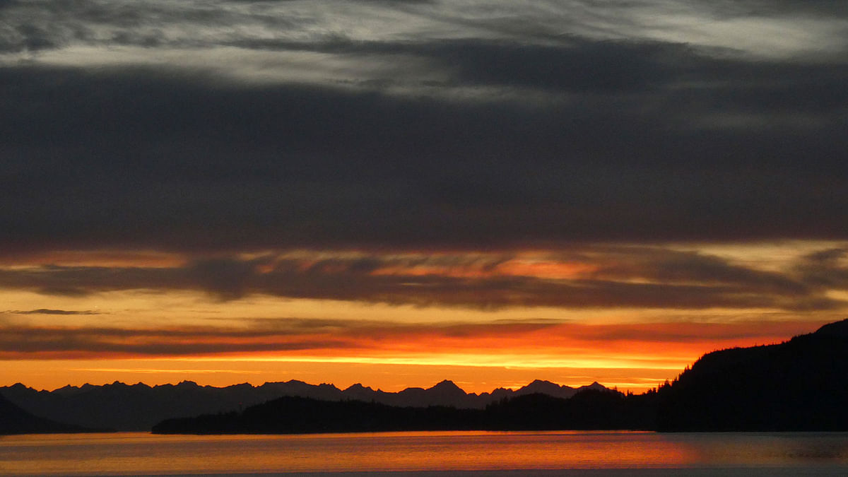 In this photo taken on 19 June 2018, residents of Juneau, Alaska, were treated to a brilliant sunset glimpsed here from Douglas Island. Even at the late hour, people were still out reveling in the nice weather, on boats and even water skis. Photo: AP