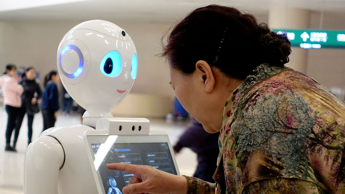 Woman touches a screen on a robot developed by iFlytek at the outpatient hall of a hospital in Beijing. Photo: Reeuters