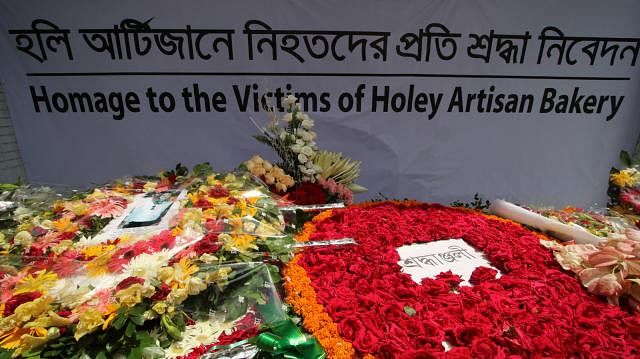 People offer flowers to pay their respect to the victims of Holey Artisan Bakery on Sunday in capital`s Gulshan-2. Photo: Abdus Salam